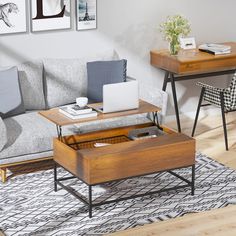 a living room with a couch, coffee table and laptop on top of the table