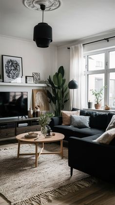 a living room filled with furniture and a flat screen tv on top of a wooden table