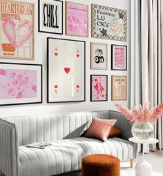 a living room filled with pink and blue art on the wall next to a couch