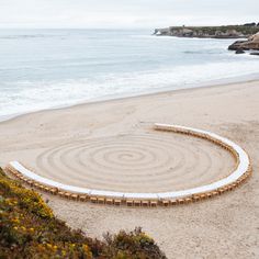 a circular bench sitting on top of a sandy beach