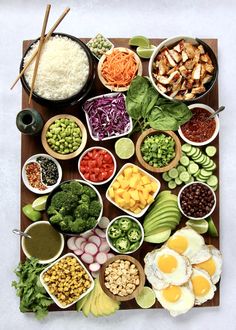 an assortment of food is displayed on a wooden tray