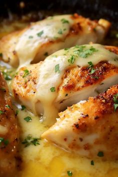 some chicken is covered with cheese and parsley