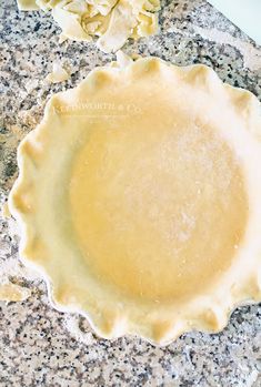 an uncooked pie crust sitting on top of a granite counter