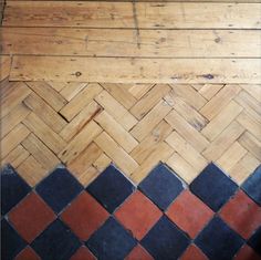 the floor is made out of wood and has black, red and white tiles on it