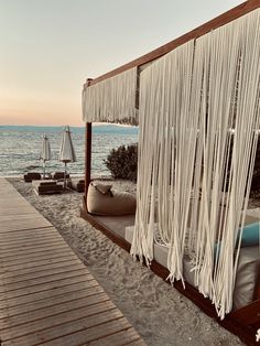 a bed on the beach next to an umbrella