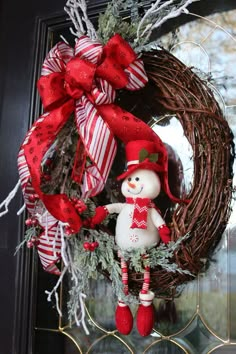 a christmas wreath with a snowman hanging from it