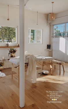 an empty room with white walls and wooden floors is pictured in this image, there are several tables on the floor