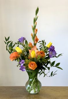 a vase filled with lots of different colored flowers