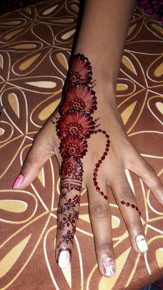 a woman's hand with hennap and flowers on the top of it