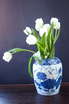 a blue and white vase with flowers in it