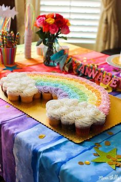 a rainbow themed birthday party with cupcakes and decorations