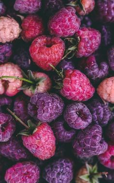 raspberries and other fruits are piled together