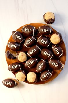 chocolate covered candies with footballs on them in a wooden bowl next to cookies