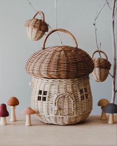 a wicker basket sitting on top of a table next to small mushrooms and trees