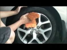 a person is cleaning the rim of a car