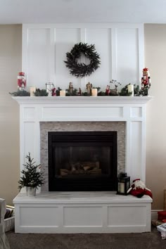 the fireplace mantle is decorated with candles and wreaths