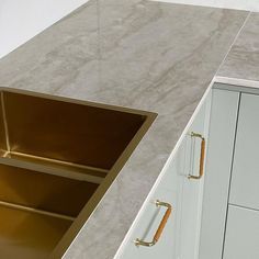 a kitchen counter top with a sink and cupboards in the corner next to it