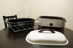 a toaster sitting on top of a wooden table next to a black and white pot