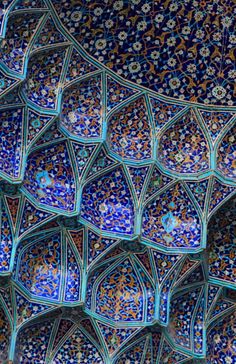 an intricately designed wall with blue and gold tiles on it's sides, in the city of fez