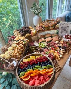 a table filled with lots of different types of food on top of wooden trays