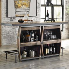 a bar with wine glasses and bottles on it next to a brick wall in a living room