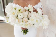 a woman holding a bouquet of white flowers