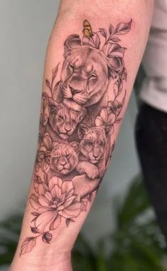 a woman with a tattoo on her arm that has lions and flowers on it,