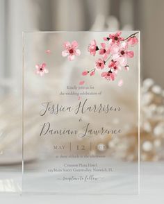 an elegant wedding card with pink flowers on the front and bottom, is shown in clear acrylic