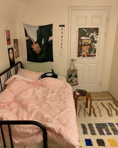 a bedroom with a bed, rug and pictures on the wall above it is shown