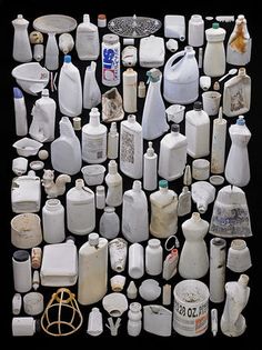 many white bottles and containers are arranged on a black surface