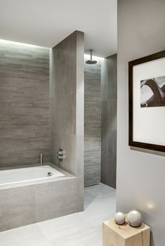 a bathroom with a bathtub, sink and framed photograph on the wall next to it