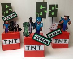 some minecraft figurines sitting on top of red blocks with green and black letters