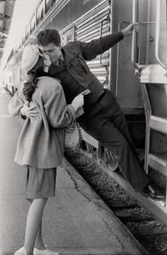 a man and woman leaning on the side of a train