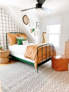 a bed room with a neatly made bed and a ceiling fan