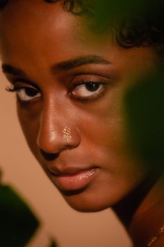 a close up of a woman's face with piercings on her nose and eyes