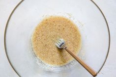 a glass bowl filled with brown sugar and a wooden spatula on top of it