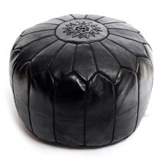 a black leather poufce with an intricate design on the top and bottom side