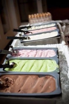 four trays of ice cream lined up on a table