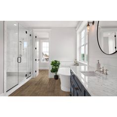 a large bathroom with marble counter tops and white walls