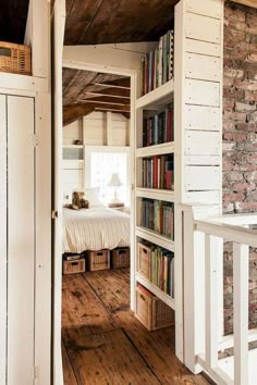 an open door leading to a bedroom with bookshelves and a bed in it