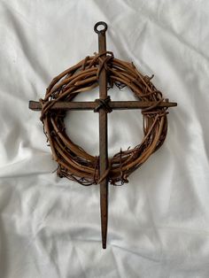 a cross made out of branches on top of a white sheet