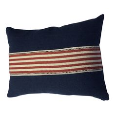 a blue pillow with red and white stripes on the front, sitting against a white background