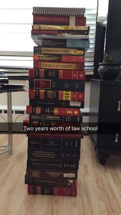 a stack of books sitting on top of a hard wood floor