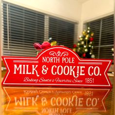 a red sign that says north pole milk and cookie co sitting on top of a table