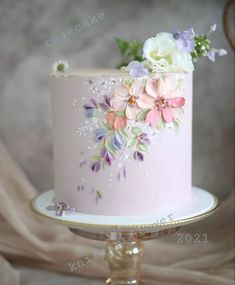 there is a pink cake with flowers on it