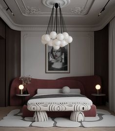 a large bed sitting under a chandelier next to a painting on the wall