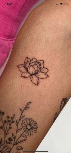 a woman's arm with a flower tattoo on it