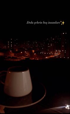 a hat sitting on top of a table in front of a city skyline at night