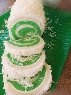 a green plate topped with lots of food on top of a wooden table