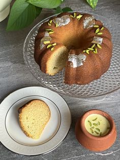 a bundt cake sitting on top of a glass plate next to a small bowl